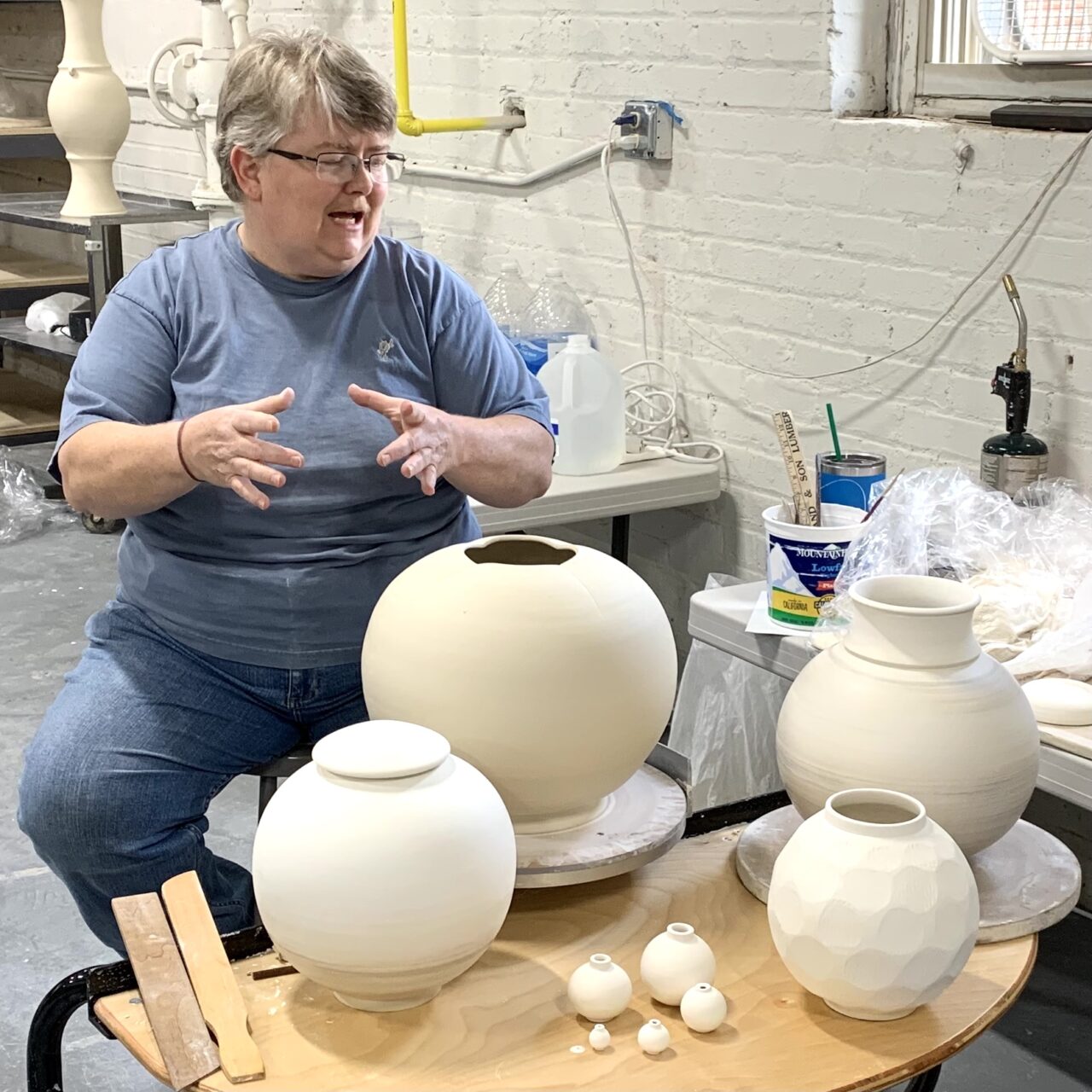 Julia Mann talking through some of her leather hard pots, moon shaped