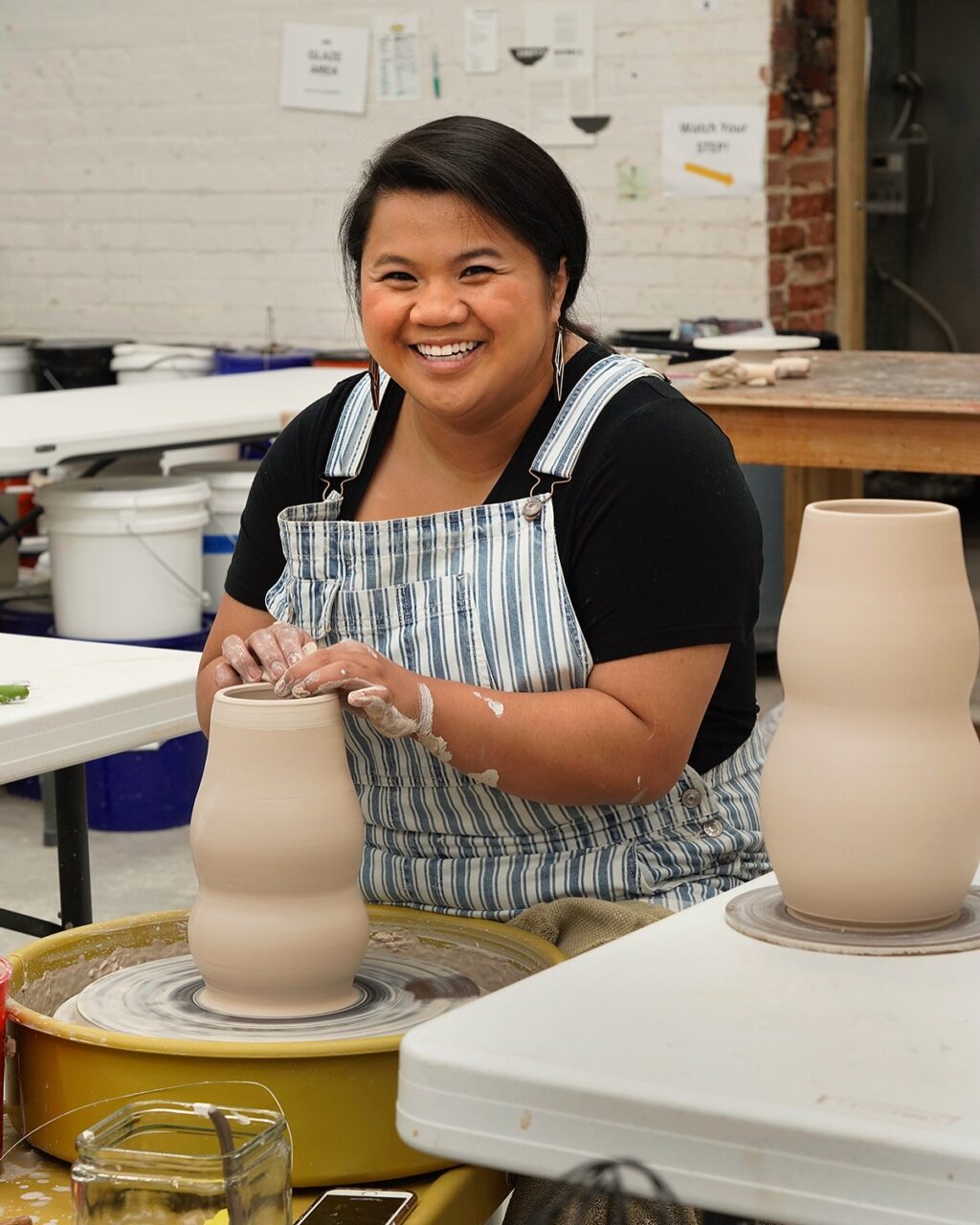Katie Meili Messersmith throwing vases at the potters wheel in ISM studio