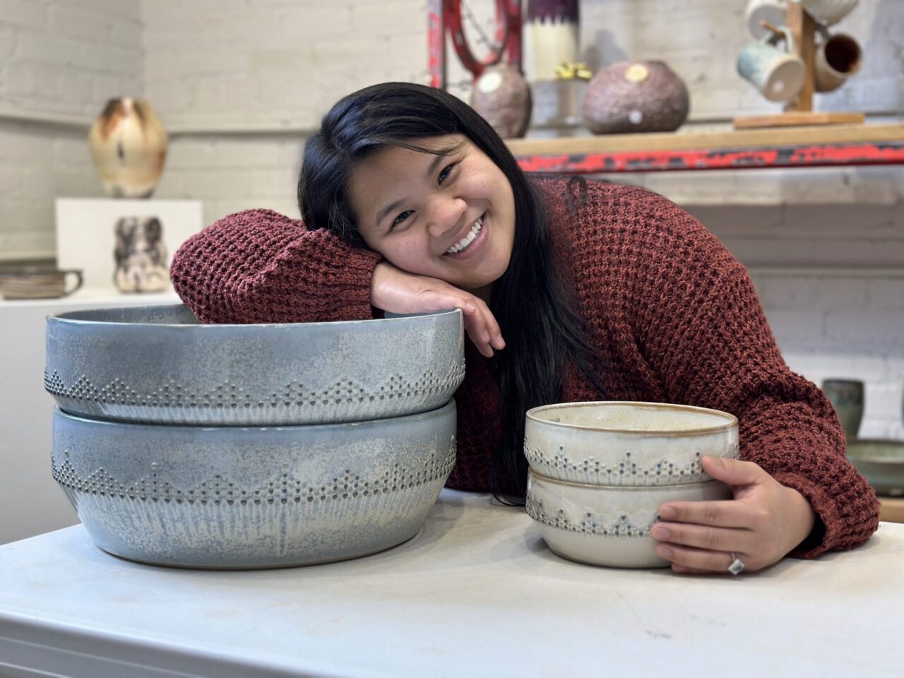 Katie Meili Messermith with finished pots, dot pots, large pasta bowls, dotted pasta bowl, smiling