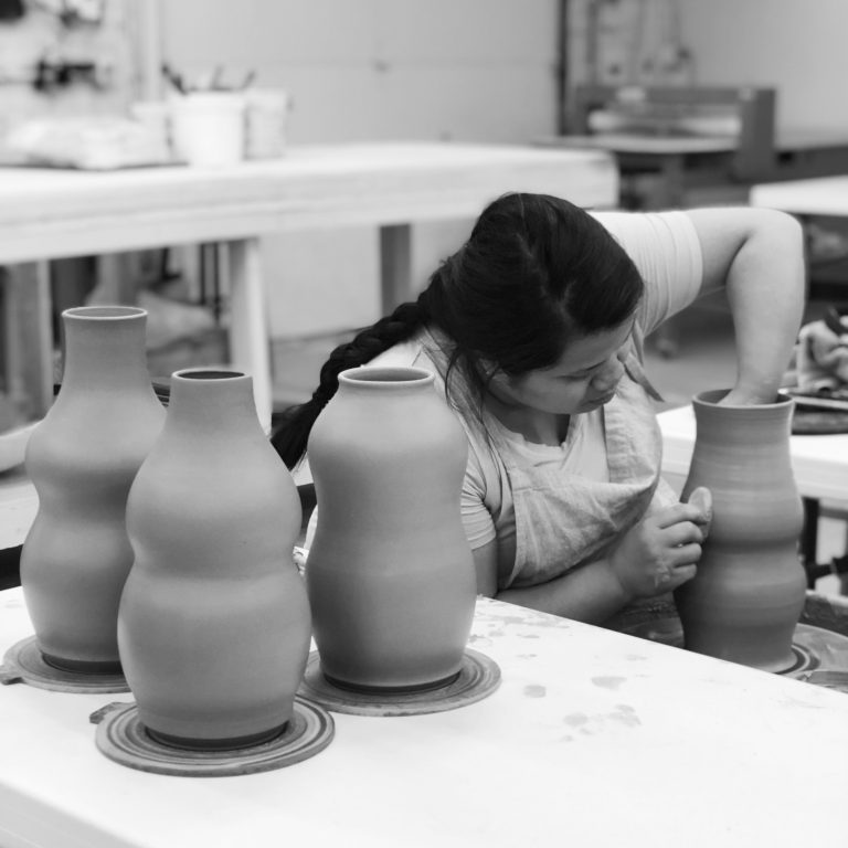 Katie Meili Messersmith throwing vases on the potters wheel in ISM studio