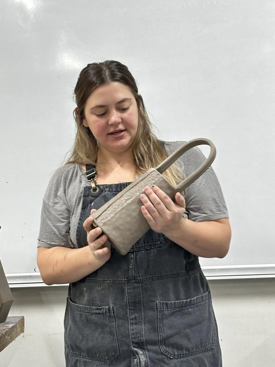 Kyra Pruitt sharing about leather-hard pot in her hands