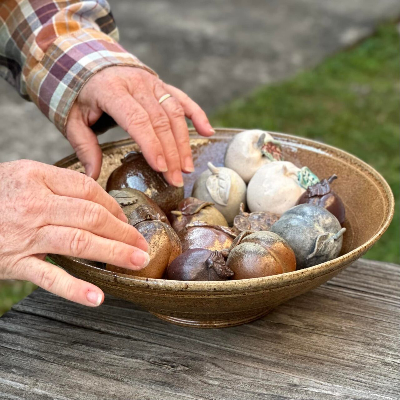 Close up of Karen Dubois hands on finished fruit pots in a bowl