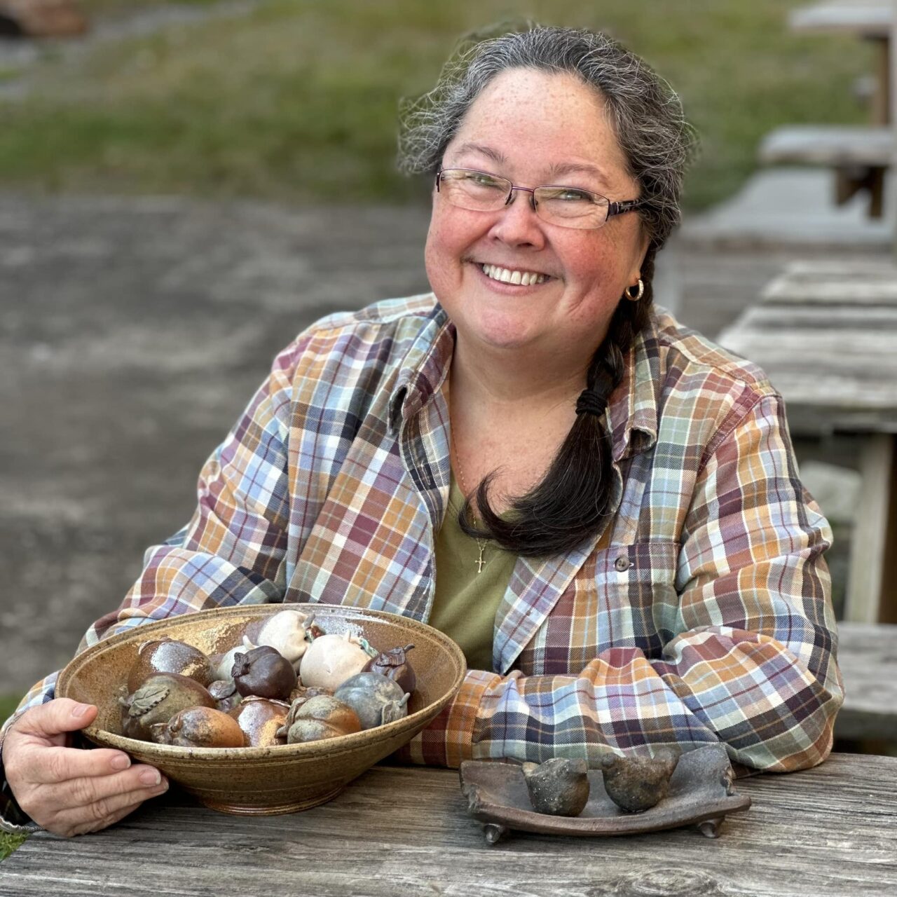 Karen Dubois headshot with finished pots, small fruit