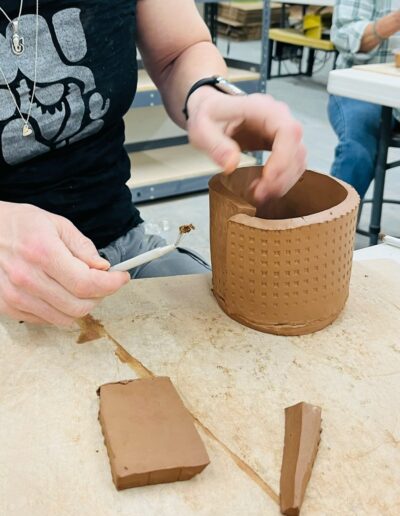 Teaching Center student scoring clay, slab work, hand building class